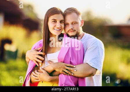 Der Mann umarmt die lächelnde Frau, das Sommerfamilienporträt in der Natur. Stockfoto