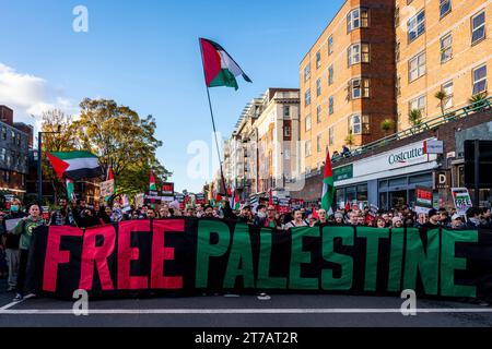Die Menschen marschieren durch London mit Einem Banner für das freie Palästina, das zu Einer Waffenruhe im Gazastreifen während des Marsch für Palästina-Events in London, Großbritannien, aufruft Stockfoto