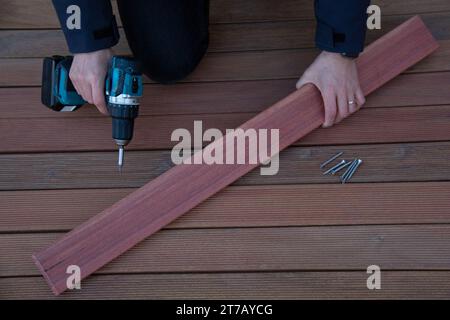 Terrassenbau, Zimmermann mit Werkzeugen und ipe-Holzplatte Stockfoto