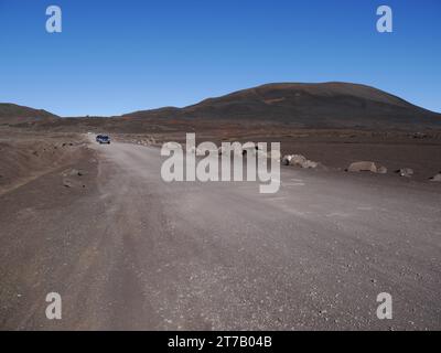 Die berühmte Straße zum Vulkan, Plaine des Sables, Insel Réunion, Frankreich. Staubige Straße zum Pas de Bellecombe in vulkanischem Sand und einsamer Landschaft Stockfoto