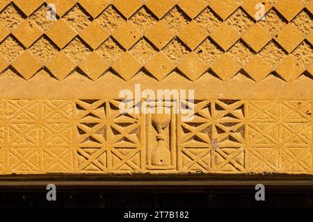 Sanduhrmotiv über dem Südeingang der normannischen Kirche St. Michael im Dorf Guiting Power in Cotswold, Gloucestershire, England, Großbritannien Stockfoto