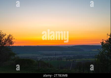 Ein farbenfroher Sonnenuntergang über dem South Downs National Park aus Butser Hill, Queen Elizabeth Country Park, Hampshire, England, Großbritannien Stockfoto