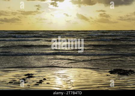 Ein schöner goldener Sonnenuntergang am Ufer der Ostsee, goldener Sonnenuntergang am Meer Stockfoto