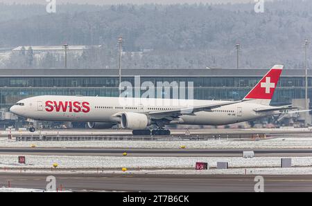 Swiss International Airlines eine Boeing 777-3DEER von Swiss International Airlines startete von Startbahn 28 des in winterlicher Landschaft liegenden Flughafen Zürich. Registrierung HB-JNE. Zürich, Schweiz, 18.12.2022 *** Swiss International Airlines Eine Boeing 777 3DEER der Swiss International Airlines startet von der Start- und Landebahn 28 des Flughafens Zürich Registrierung HB JNE Zürich, Schweiz, 18 12 2022 in der Winterlandschaft Credit: Imago/Alamy Live News Stockfoto