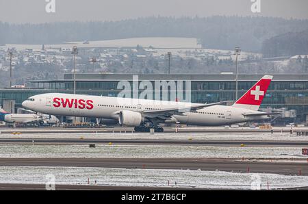 Swiss International Airlines eine Boeing 777-3DEER von Swiss International Airlines startete von Startbahn 28 des in winterlicher Landschaft liegenden Flughafen Zürich. Registrierung HB-JNE. Zürich, Schweiz, 18.12.2022 *** Swiss International Airlines Eine Boeing 777 3DEER der Swiss International Airlines startet von der Start- und Landebahn 28 des Flughafens Zürich Registrierung HB JNE Zürich, Schweiz, 18 12 2022 in der Winterlandschaft Credit: Imago/Alamy Live News Stockfoto