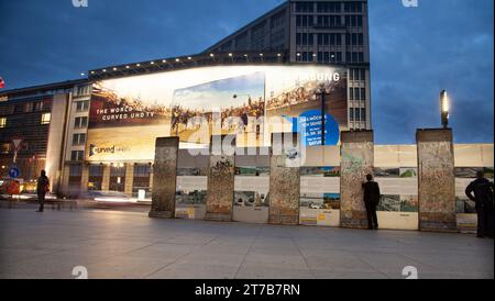 Touristen, die Graffiti und Kaugummi auf der Berliner Mauer-Ausstellung im Postdammer plaz 2014 anschauen Stockfoto