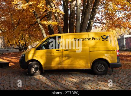 Berlin, Deutschland. November 2023. 13.11.2023, Berlin. Ein gelber Postwagen, der an einem Herbsttag im November unter einem Baum geparkt wurde, dessen Blätter herbstlich gelb geworden sind. Kredit: Wolfram Steinberg/dpa Kredit: Wolfram Steinberg/dpa/Alamy Live News Stockfoto