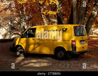 Berlin, Deutschland. November 2023. 13.11.2023, Berlin. Ein gelber Postwagen, der an einem Herbsttag im November unter einem Baum geparkt wurde, dessen Blätter herbstlich gelb geworden sind. Kredit: Wolfram Steinberg/dpa Kredit: Wolfram Steinberg/dpa/Alamy Live News Stockfoto