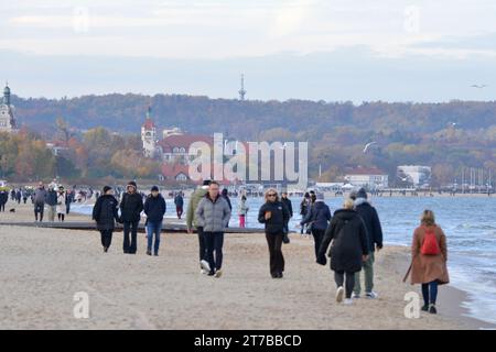 Menschen mit Jacken gehen am Danziger Strand in der Nähe von Sopot bei kaltem Wetter in Danzig, Polen, Europa, EU Stockfoto