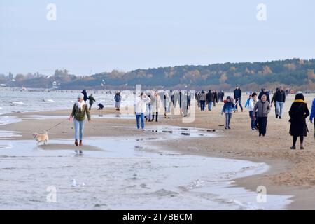 Menschen mit Jacken, die bei kaltem Wetter am Strand von Danzig, Polen, Europa, EU spazieren gehen Stockfoto