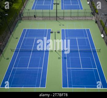 Blick auf die Drohne mit Blick auf neu bemalte Tennisplätze in Grün und Blau mit Lichtern. Stockfoto