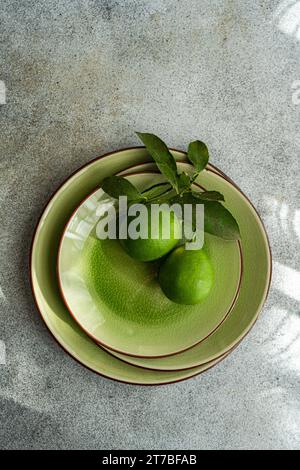 Blick von oben auf eine mit zwei frisch gepflückten Limetten dekorierte Umgebung Stockfoto