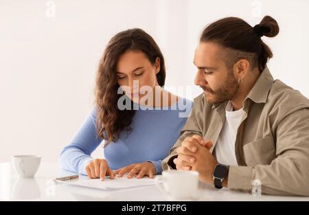 Liebevolles Paar, das Papiere hält und Dokumente sorgfältig studiert Stockfoto