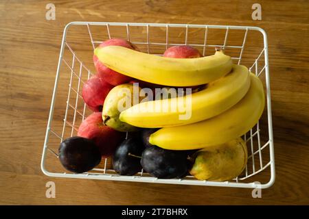 Korb mit frischem Obst auf dem Tisch in der Küche Stockfoto