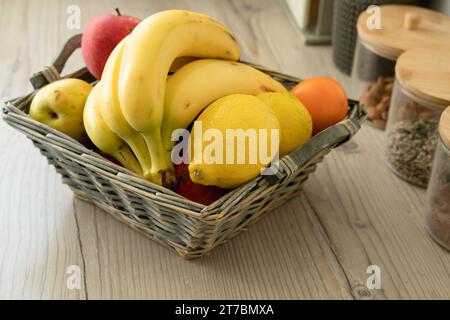 Korb mit frischem Obst auf dem Tisch in der Küche Stockfoto