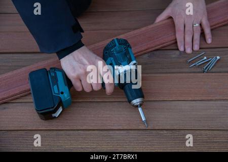 Terrassenbau, Zimmermann mit Werkzeugen und ipe-Holzplatte Stockfoto