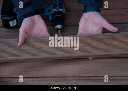 Deckschreiner hält ipe-Holzbrettholz auf Terrassendielen aus nächster Nähe Stockfoto