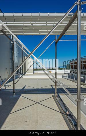 Ein Blick durch einen Rohrstützrahmen in Richtung eines adiabatischen Kondensators auf dem Dach eines CO2-Kühllagers (Industriekühlung) Stockfoto