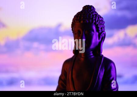 Buddha Purnima und Vesak Tageskonzept, Buddha-Statue mit dezentem Licht vor wunderschönem und farbenfrohen Hintergrund aus nächster Nähe. Meditation Stockfoto