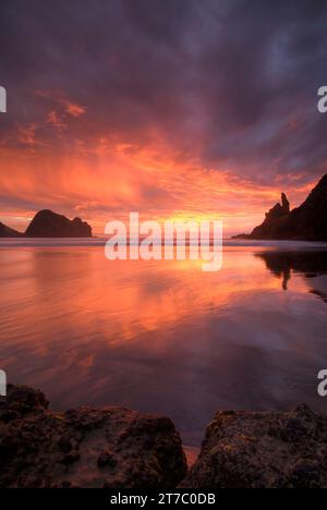 Sonnenuntergang am Piha Beach, westlich von Auckland, auf Neuseelands Nordinsel. Stockfoto