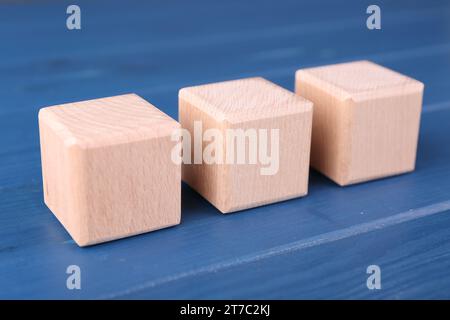 Internationale Organisation für Normung. Würfel mit der Abkürzung ISO auf blauem Holztisch, Großansicht Stockfoto