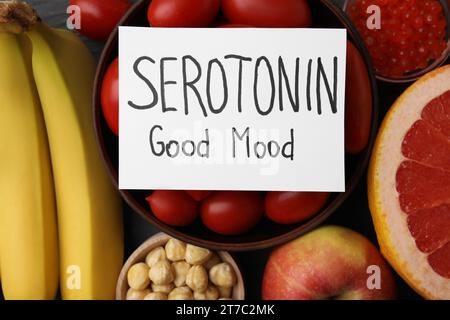 Viele verschiedene Produkte und Karte mit dem Satz Serotonin gute Laune auf dem Tisch, flache Lay. Natürliche Antidepressiva Stockfoto