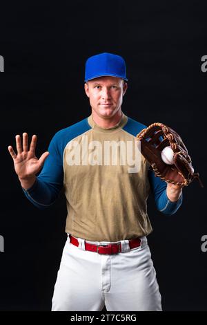 Baseballspieler mit Kappe posiert mit Handschuh Stockfoto