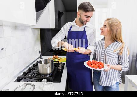 Glückliches Paar, das Spaghettitopf mit gekochtem Wasser macht Stockfoto