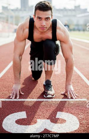 Portrait souveräne männliche Athleten, die Startlinie der Rennstrecke Stockfoto