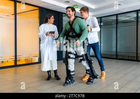 Mechanisches Exoskelett, Ärztin mit Geräteschaltung mit behinderter Person mit Roboterskelett in der Rehabilitation, Physiotherapie in der Moderne Stockfoto