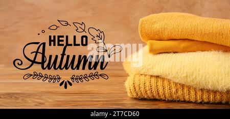 Banner mit verschiedenen warmen Pullis und Text HALLO, HERBST Stockfoto