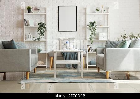 Helles Wohnzimmer mit gemütlichen grauen Sofas und Couchtisch Stockfoto