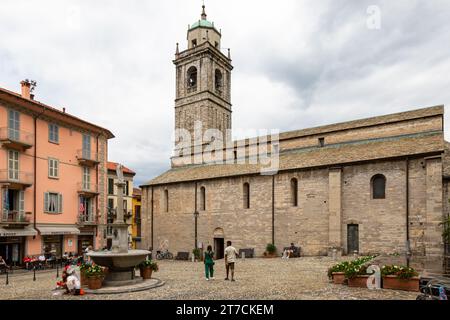 Die Basilika St. Jakobus aus dem 12. Jahrhundert steht hinter einem Brunnen auf dem Kirchplatz in Bellagio, Lombardei, Italien. Stockfoto