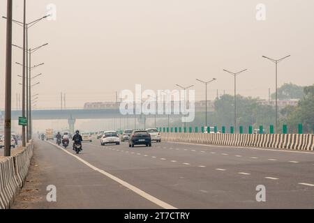 Neu-Delhi, Indien. November 2023. Delhi Metro Rail, gesehen an einem verdampften Tag unter steigender Luftverschmutzung nach dem Diwali Festival auf dem Meerut Expressway. Diwali-Feuerwerk verschlimmert Delhis Luftverschmutzung und setzt schädliche Schadstoffe frei. Das Zusammenspiel von Feuerwerkskörper-Emissionen, atmosphärischen Bedingungen und vorhandenen Verschmutzungsquellen führt zu einem starken Anstieg der Luftverschmutzung. Quelle: SOPA Images Limited/Alamy Live News Stockfoto