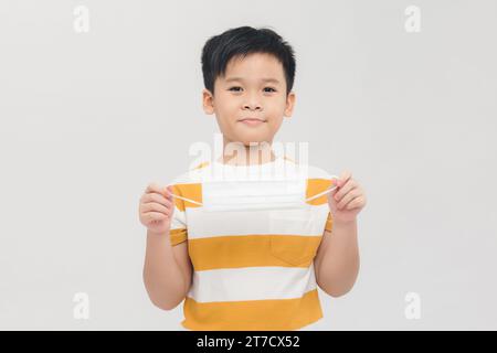 Junger klug aussehender gesunder asiatischer Teenager mit medizinischer Gesichtsmaske in der Hand, Smile.Panorama Stockfoto