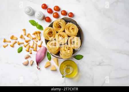 Rohe Zutaten für Pilznudeln, verstreut auf Marmorhintergrund Stockfoto