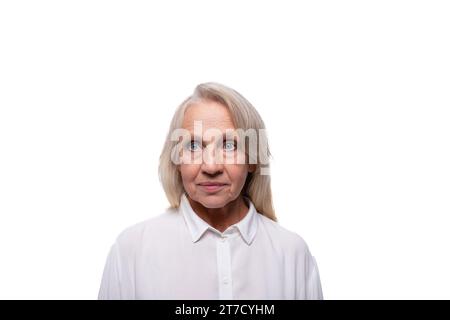 65 Jahre alte strenge europäische reife Frau in einem Hemd auf weißem Hintergrund Stockfoto