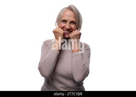 65-jährige zufriedene europäische reife Frau mit kurzen Haaren auf weißem Hintergrund Stockfoto