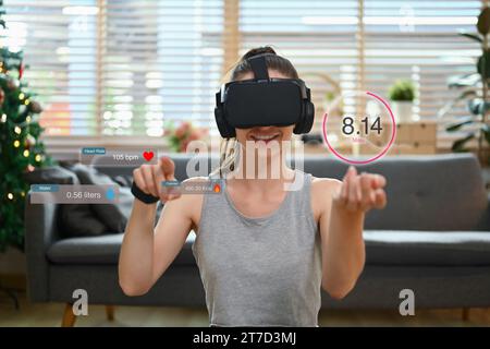 Junge Sportfrau überprüft die Trainingsergebnisse oder Fortschrittsaktualisierungen auf Virtual-Reality-Brillen Stockfoto