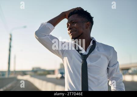 Afroamerikaner, der sich um seine Probleme sorgt, während er die Brücke in der Stadt entlang läuft Stockfoto