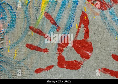 Weiße verputzte Wand mit roter Farbe. Farbspritzer an der Wand. Lackierte Putzwand. Abstrakter Hintergrund. Lackierte Gipsstruktur. Stockfoto