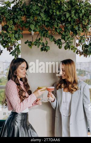 Attraktive Frauen stoßen im Restaurant oder in der Bar an und trinken bei Cocktails Stockfoto