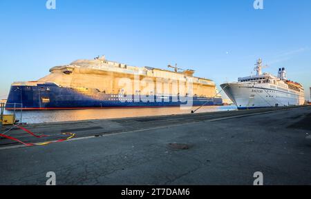 Das alte klassische kleine Passagierschiff MS Astor vs. Das riesige brandneue Kreuzfahrtschiff Celebrity Apex im Hafen von St. Nazaire, die Werft Chantiers de l'Atlantique, Docks Stockfoto