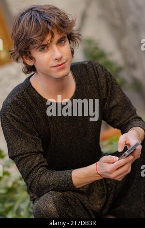 Ein Porträt eines hübschen jungen kaukasischen Mannes in einem schwarzen Outfit. Stockfoto