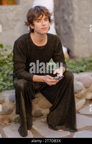 Ein Porträt eines hübschen jungen kaukasischen Mannes in einem schwarzen Outfit. Stockfoto