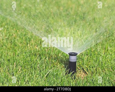 Funktionierender Smart Garden aktiviert mit vollautomatischem Sprinklerbewässerungssystem im Green Park Bewässerungsrasen Stockfoto