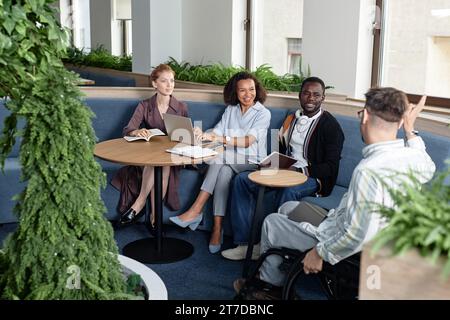 Gruppe von jungen Geschäftsleuten, die gemeinsam bei Geschäftstreffen im Büro diskutieren Stockfoto