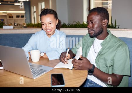 Ein paar Kollegen arbeiten während eines Meetings im Café zusammen an einem Laptop Stockfoto