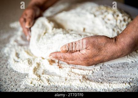 Hände Teig. Weibliche Hände machen Teig für Pizza. Der Küchenchef in der professionellen Küche bereitet Teig zu. Zubereitungsteige Stockfoto