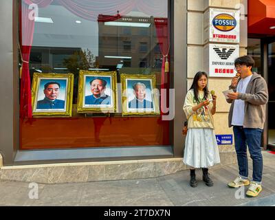 Peking, China, Straßenszene, Paar auf einem Date, Leute, Einkaufsstraße, Wangfujing St., Center City, Porträts berühmter chinesischer Führer im Shop Stockfoto